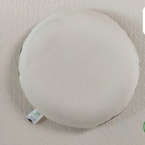 A round, white pillow made from natural latex, featuring a label indicating it's made from 100% natural latex.