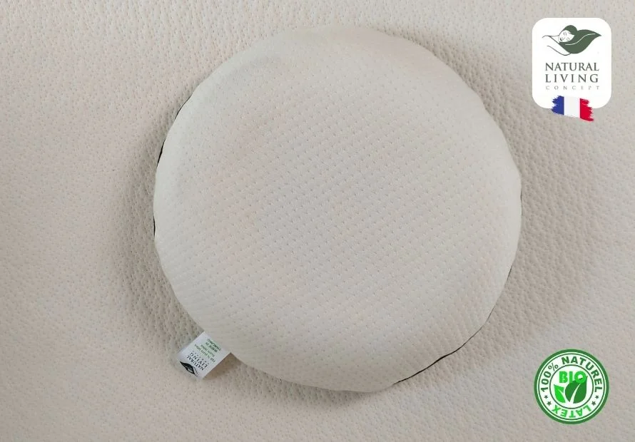 A round, white pillow made from natural latex, featuring a label indicating it's made from 100% natural latex.