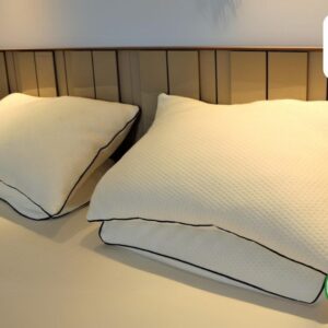 A pair of plush latex flake pillows rest on a made bed, showcasing their natural comfort and support.