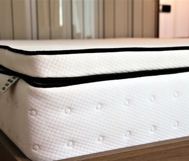 Un matelas en latex d'apparence confortable avec une housse blanche et un bord noir, doté d'un design respirant.
