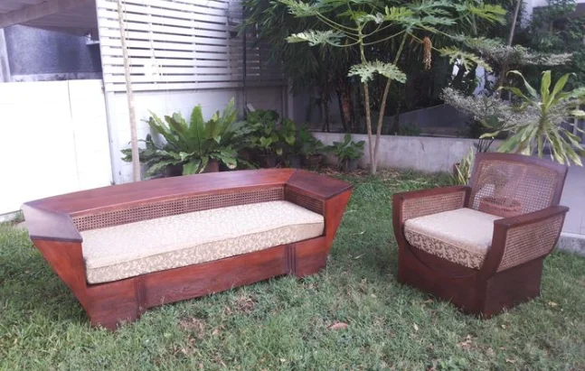 Un bel agencement de sièges d'extérieur comprenant un canapé incurvé et un fauteuil assorti, tous deux avec des détails en rotin tressé.