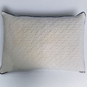 Top view of a rectangular natural latex pillow with a textured beige cover and dark edging, placed on a light gray surface.