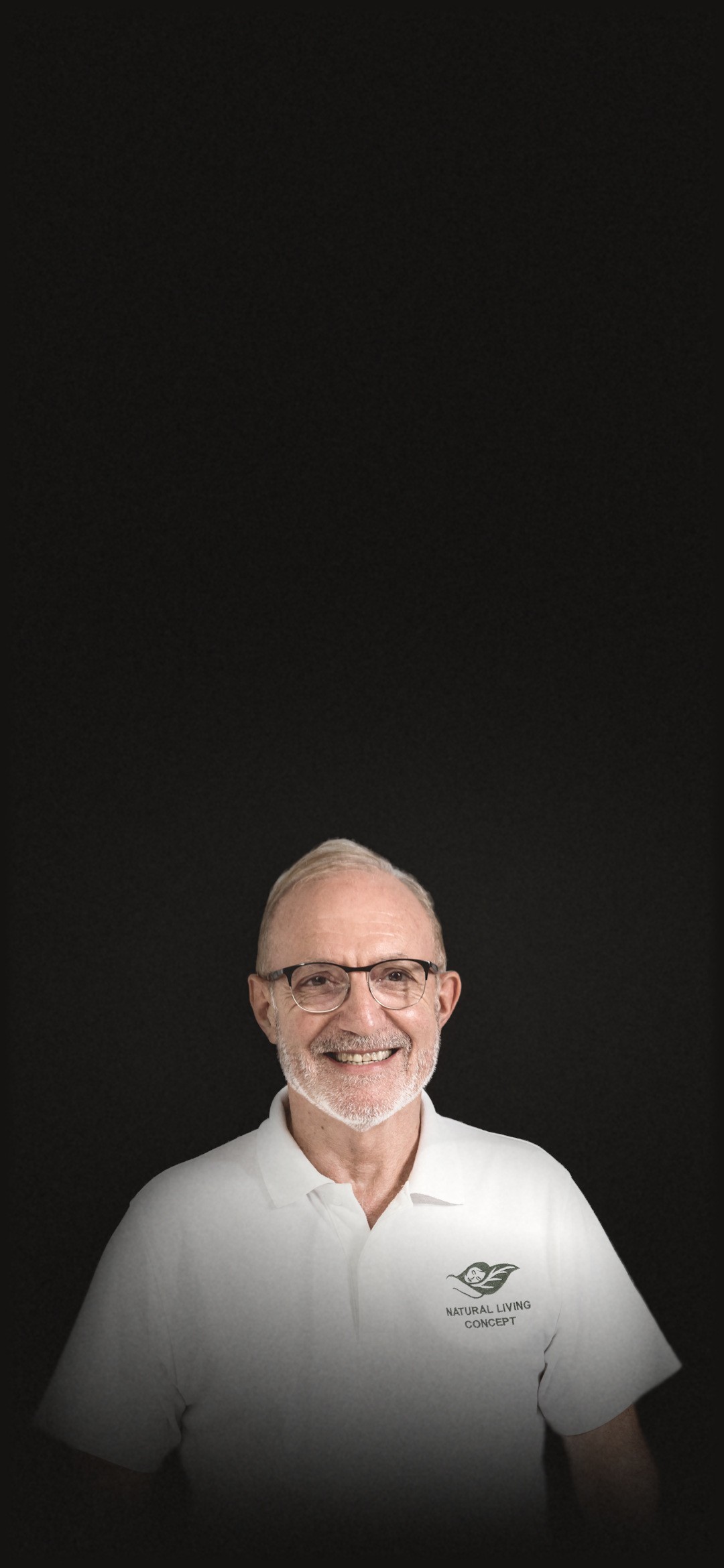 Dominique Bienfait, smiling, in glasses and a white Natural Living Concept polo.