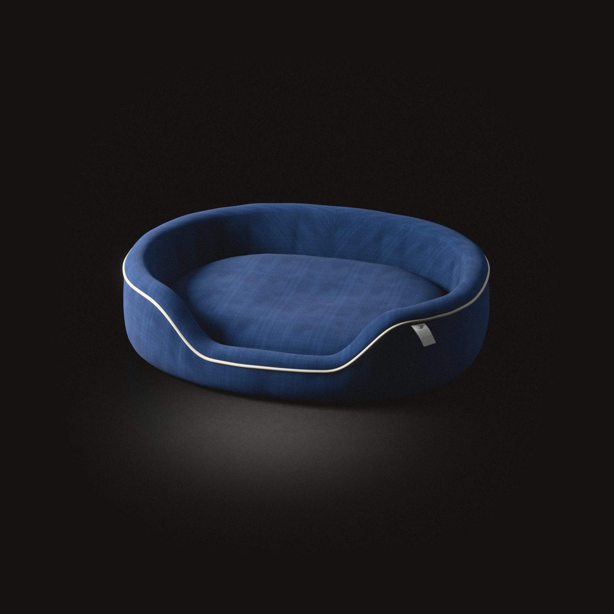 The oval dog cushion on a black floor: a raised rim edged with piping, lower at the front.