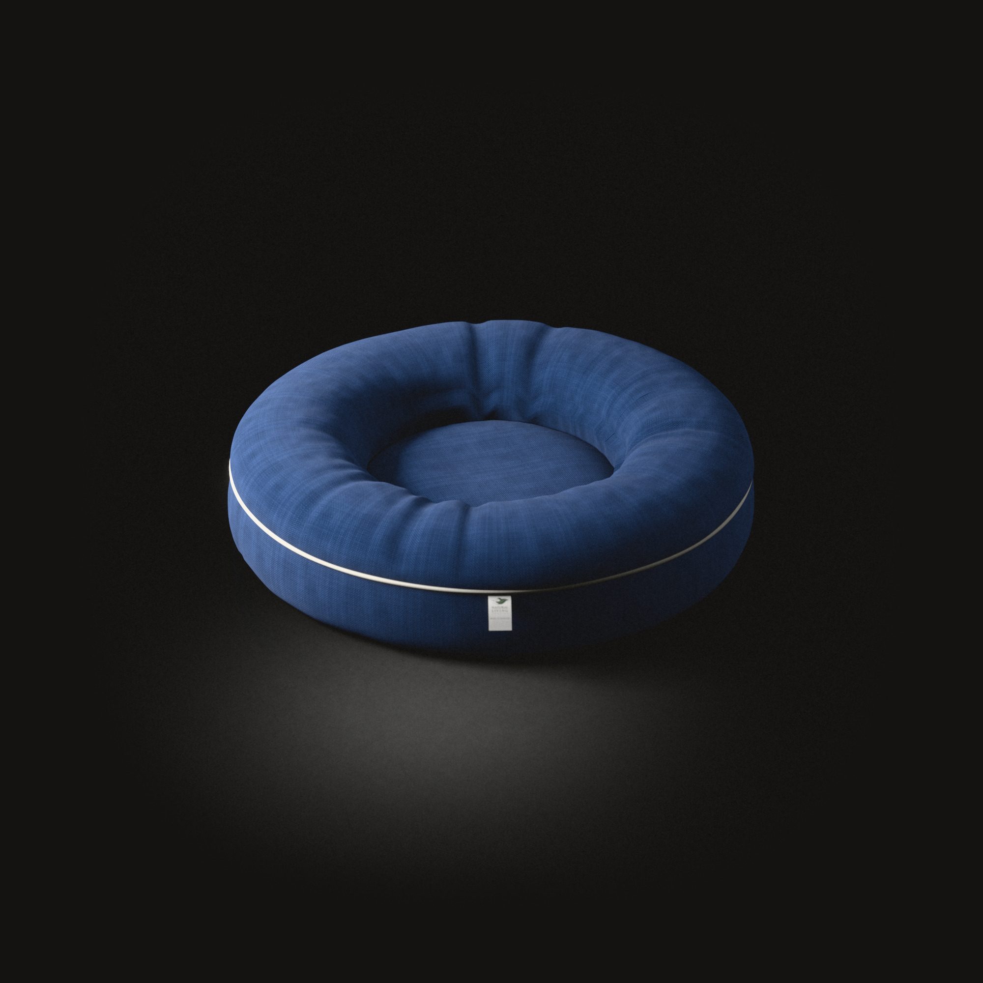 The round dog cushion on a black floor: a padded rim round a flat middle, piping round its foot.