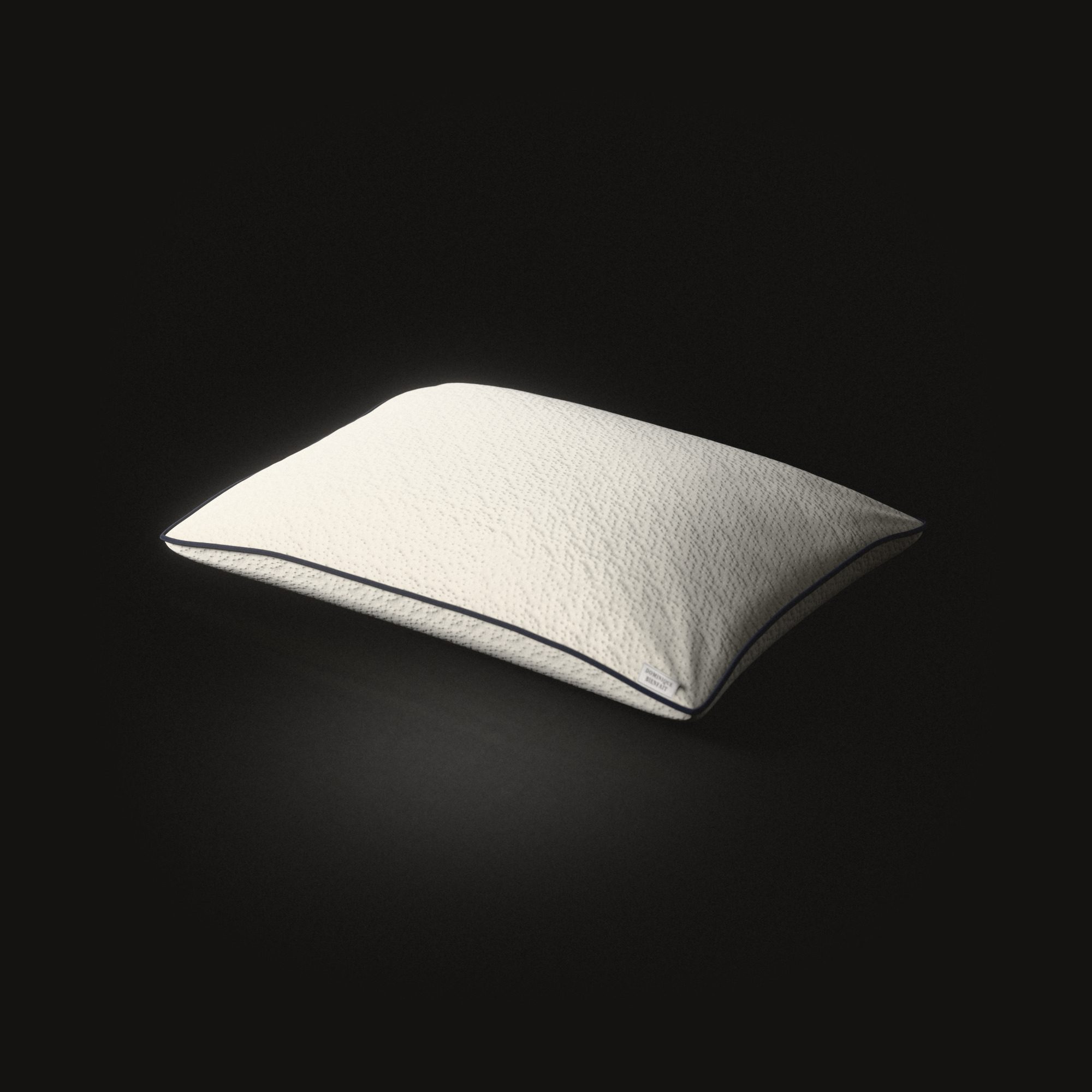 The latex pillow on a black floor: a low full dome of knitted cloth with small pits in rows, a dark cord round its seam.