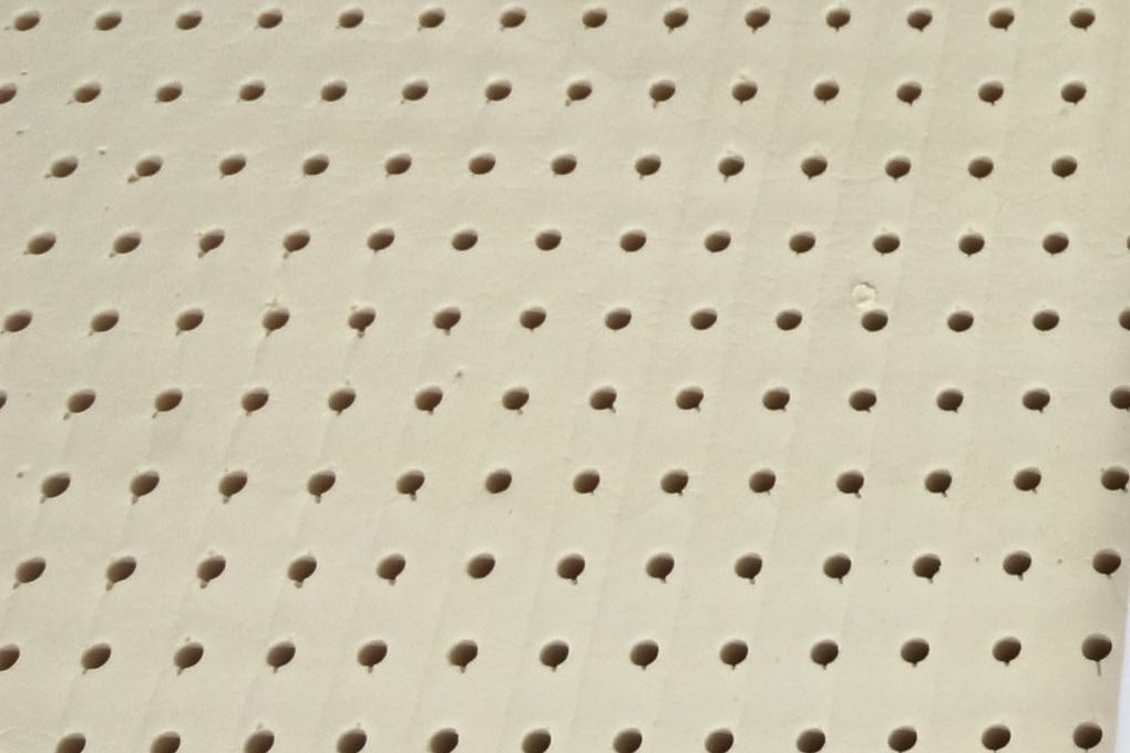 A sheet of natural latex seen close, with its rows of pin holes.